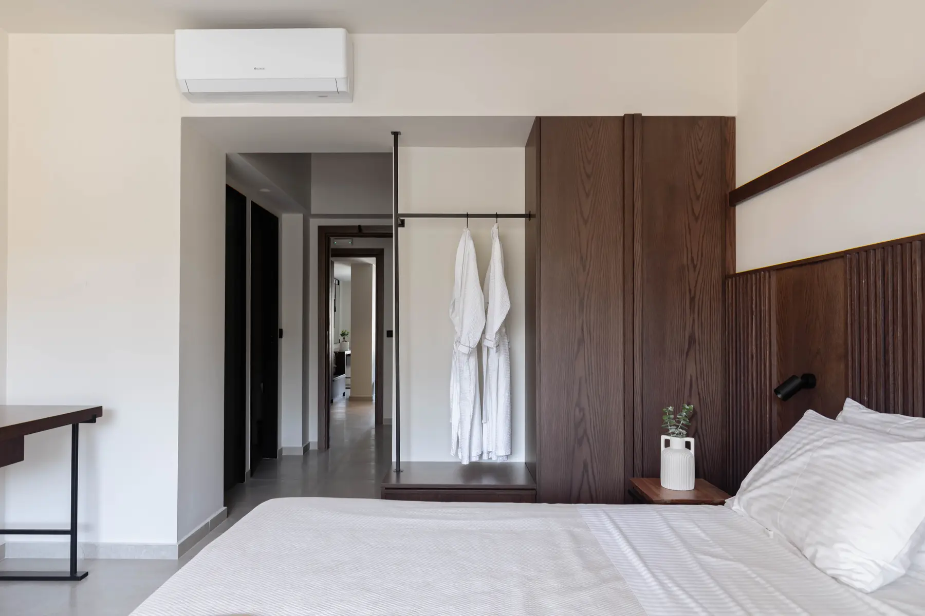 Bathrobes hung beside the oak wardrobe
