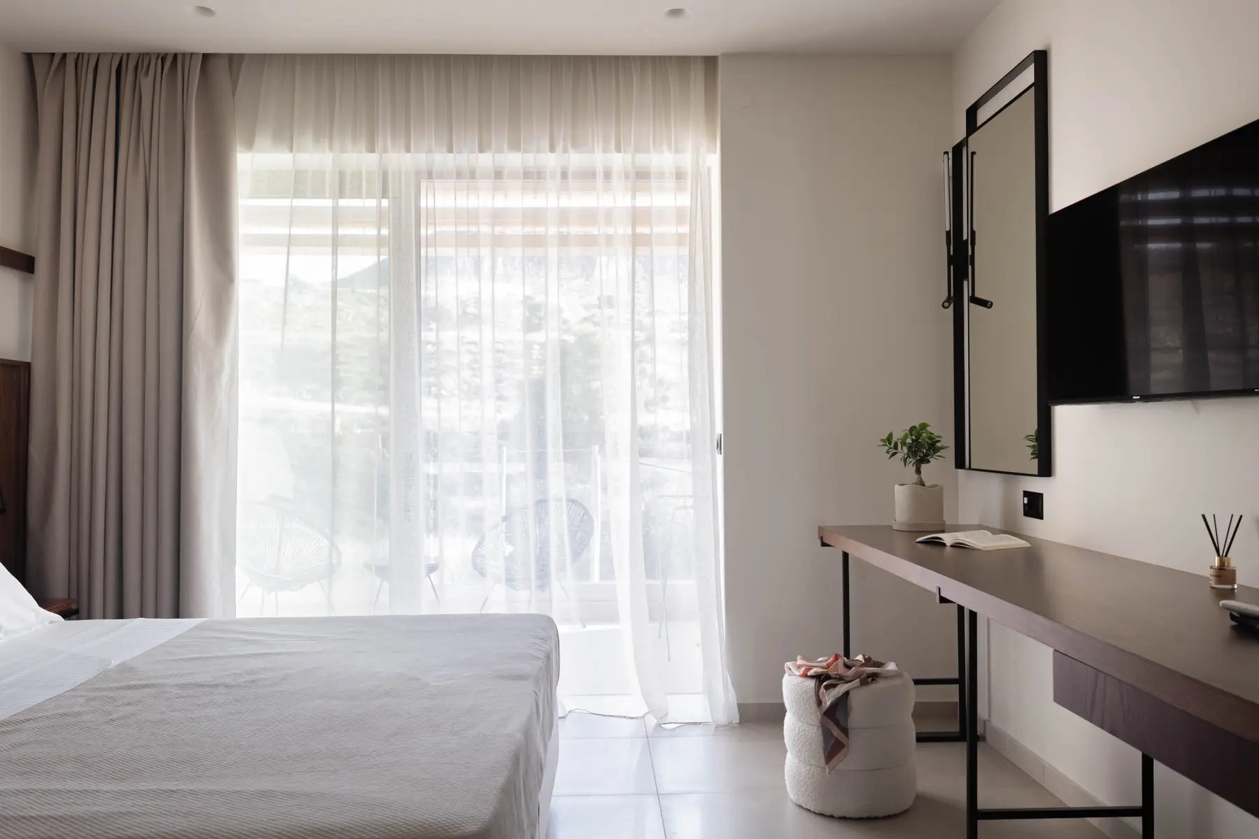 Bedroom with curtained balcony door and dressing table