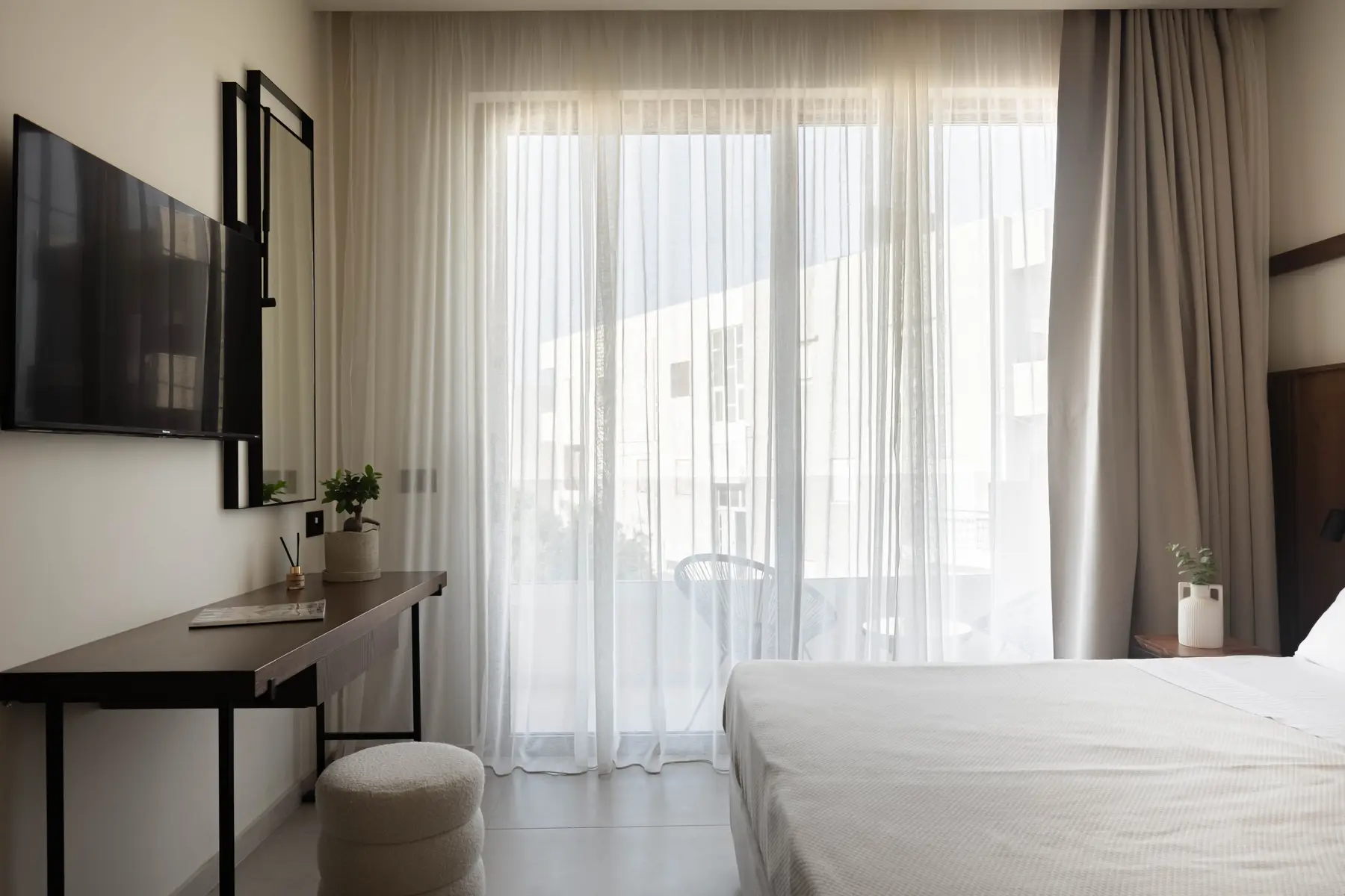 Bedroom vanity and sheer curtains to the balcony