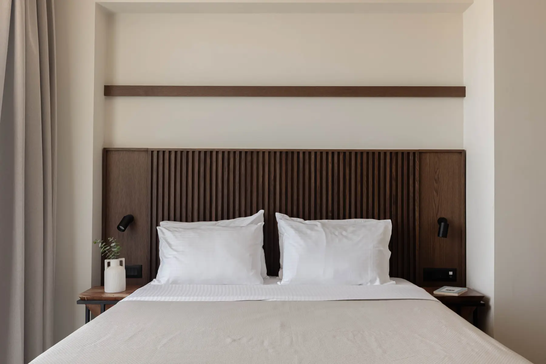 Slatted oak headboard and crisp linen in the main bedroom