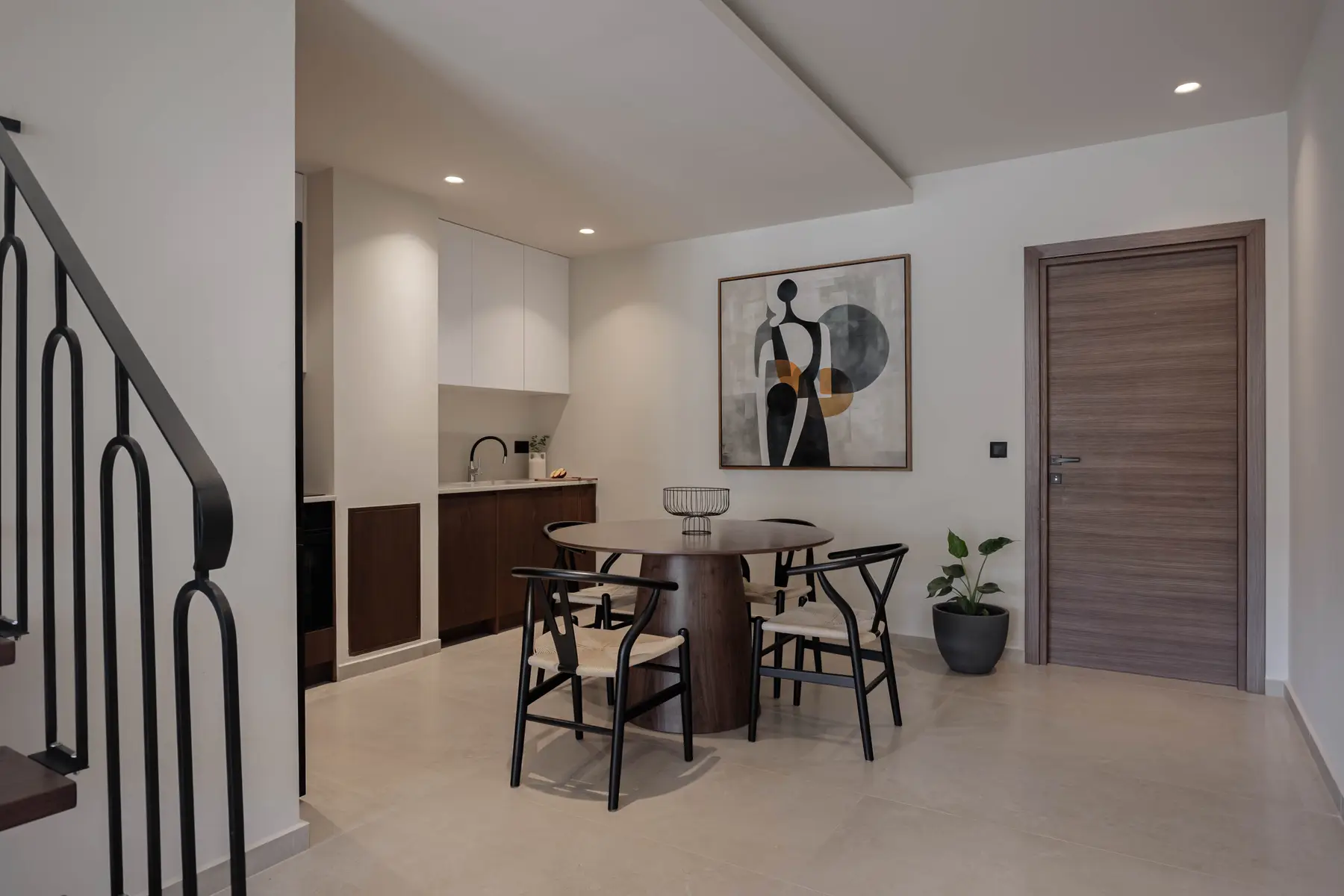 Dining table beneath abstract artwork by the entrance